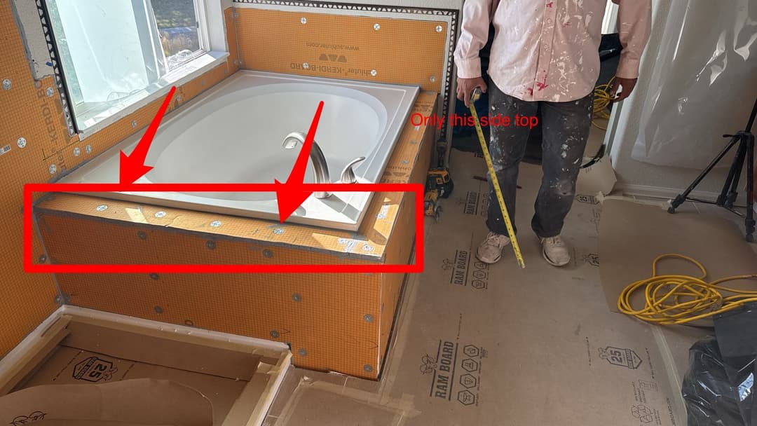 Renovation progress showing new bathtub installation and construction details in bathroom.