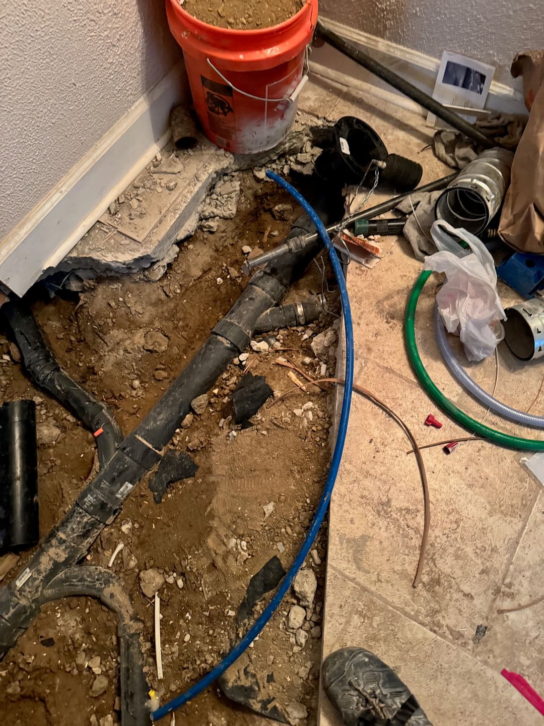 exposed plumbing and construction debris in a renovation project, featuring tools and materials