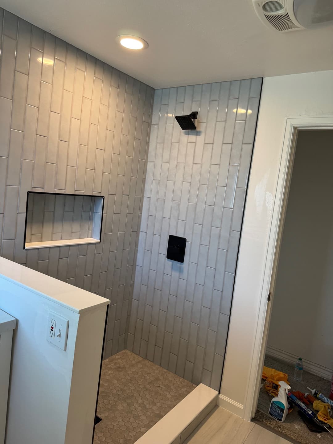 Modern bathroom featuring a spacious walk-in shower with gray tiles and a built-in niche.