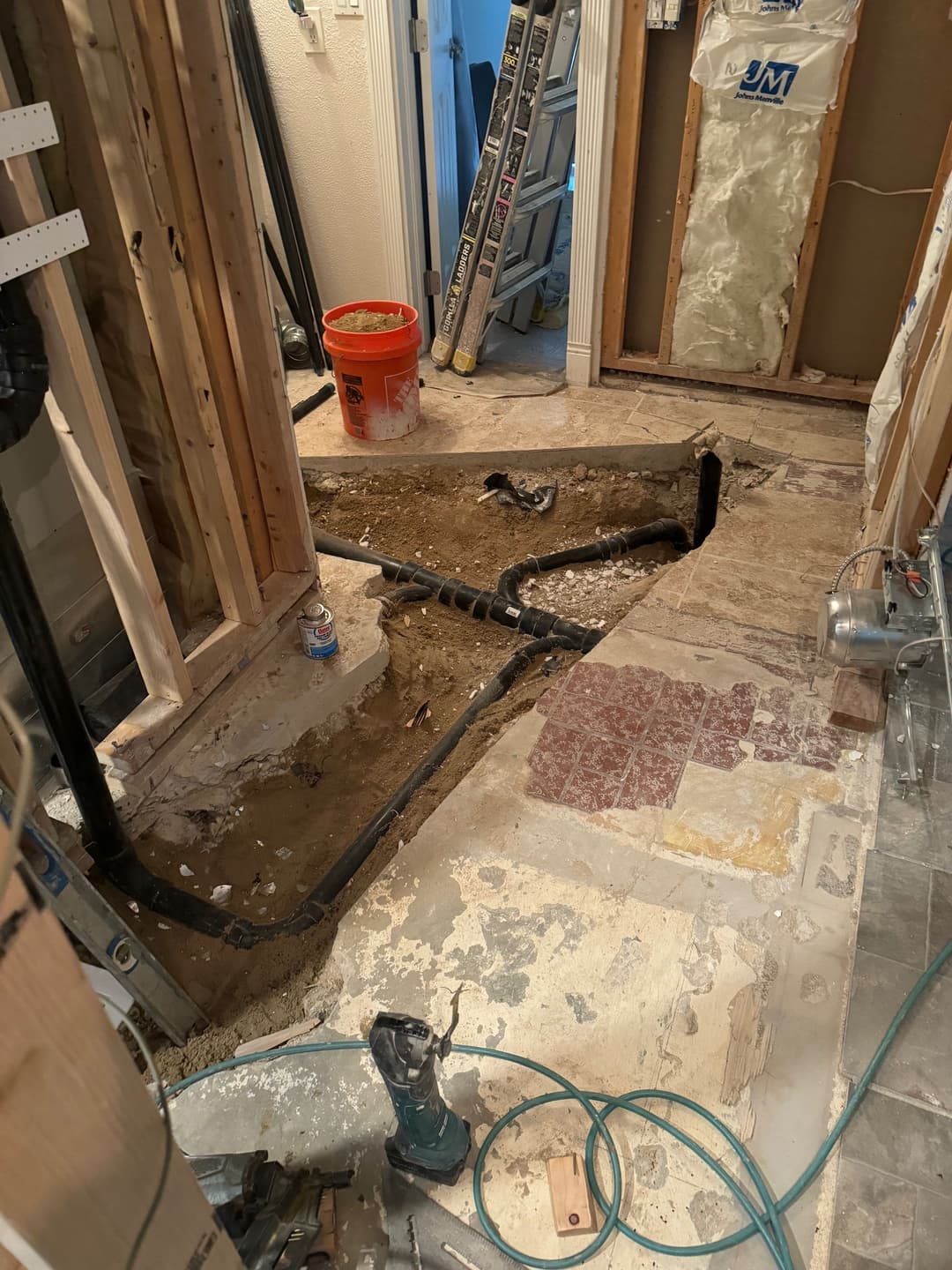 Renovation project showing exposed floor and plumbing in a home under construction.